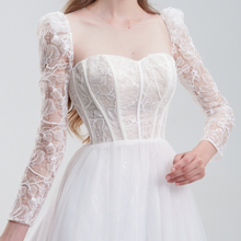Load image into Gallery viewer, A romantic A-line wedding dress with lace long sleeves, illusion details, and a flowing tulle skirt for an elegant, timeless bridal look
