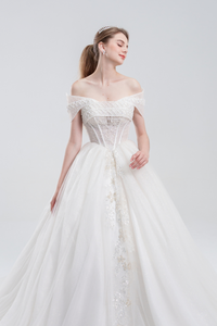
Off-the-shoulder ball gown wedding dress with sparkling tulle, beaded bodice, and voluminous skirt for a romantic, princess-inspired bridal look