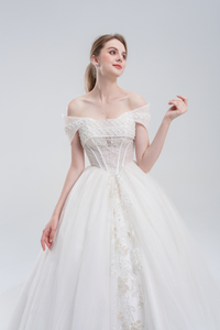 
Off-the-shoulder ball gown wedding dress with sparkling tulle, beaded bodice, and voluminous skirt for a romantic, princess-inspired bridal look