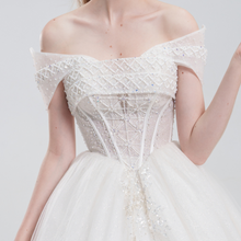 Load image into Gallery viewer, 
Off-the-shoulder ball gown wedding dress with sparkling tulle, beaded bodice, and voluminous skirt for a romantic, princess-inspired bridal look
