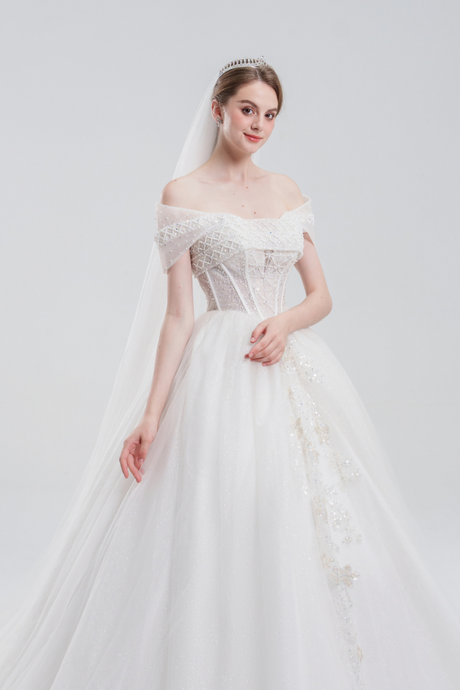 
Off-the-shoulder ball gown wedding dress with sparkling tulle, beaded bodice, and voluminous skirt for a romantic, princess-inspired bridal look