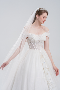 
Off-the-shoulder ball gown wedding dress with sparkling tulle, beaded bodice, and voluminous skirt for a romantic, princess-inspired bridal look