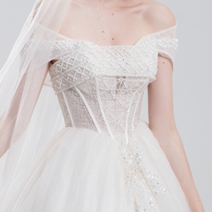 
Off-the-shoulder ball gown wedding dress with sparkling tulle, beaded bodice, and voluminous skirt for a romantic, princess-inspired bridal look