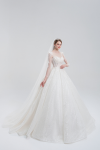 Long sleeve ball gown wedding dress with sparkling tulle, intricate beadwork, and a voluminous skirt for an elegant, romantic bridal look