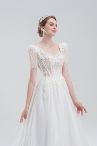 Elegant A-line wedding dress with lace puff sleeves, beaded bodice, and sparkling tulle skirt for a romantic, vintage-inspired bridal look