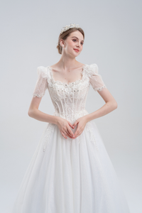 Elegant A-line wedding dress with lace puff sleeves, beaded bodice, and sparkling tulle skirt for a romantic, vintage-inspired bridal look