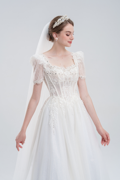 Elegant A-line wedding dress with lace puff sleeves, beaded bodice, and sparkling tulle skirt for a romantic, vintage-inspired bridal look