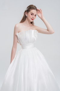 Strapless ball gown wedding dress in luxurious organza with a voluminous skirt, structured bodice, and ethereal layers for a romantic bridal look.