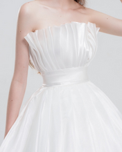 Load image into Gallery viewer, Strapless ball gown wedding dress in luxurious organza with a voluminous skirt, structured bodice, and ethereal layers for a romantic bridal look.
