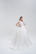 Load image into Gallery viewer, Strapless ball gown wedding dress in luxurious organza with a voluminous skirt, structured bodice, and ethereal layers for a romantic bridal look.
