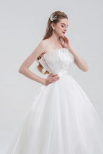 Load image into Gallery viewer, Strapless ball gown wedding dress in luxurious organza with a voluminous skirt, structured bodice, and ethereal layers for a romantic bridal look.
