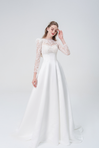 A stunning A-line wedding dress with long sleeves, flowing silhouette, soft fabric, and timeless elegance, perfect for modern and classic brides