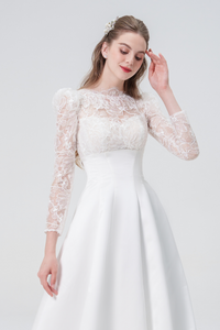 A stunning A-line wedding dress with long sleeves, flowing silhouette, soft fabric, and timeless elegance, perfect for modern and classic brides