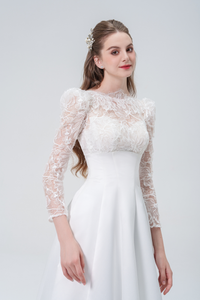 A stunning A-line wedding dress with long sleeves, flowing silhouette, soft fabric, and timeless elegance, perfect for modern and classic brides