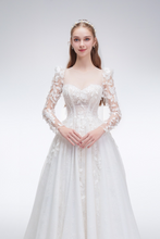 Load image into Gallery viewer, Romantic A-line wedding dress with sheer sleeves, leaf embellishments, sparkling fabric, and beaded details for an ethereal bridal look
