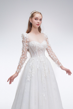 Load image into Gallery viewer, Romantic A-line wedding dress with sheer sleeves, leaf embellishments, sparkling fabric, and beaded details for an ethereal bridal look
