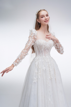 Load image into Gallery viewer, Romantic A-line wedding dress with sheer sleeves, leaf embellishments, sparkling fabric, and beaded details for an ethereal bridal look
