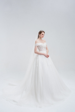 Load and play video in Gallery viewer, Off-the-shoulder ball gown wedding dress with sparkling tulle, intricate beadwork, and a voluminous skirt for a glamorous fairytale look.
