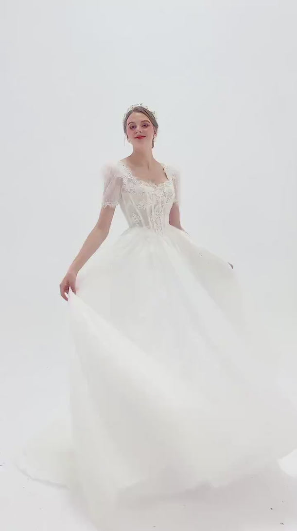 Elegant A-line wedding dress with lace puff sleeves, beaded bodice, and sparkling tulle skirt for a romantic, vintage-inspired bridal look